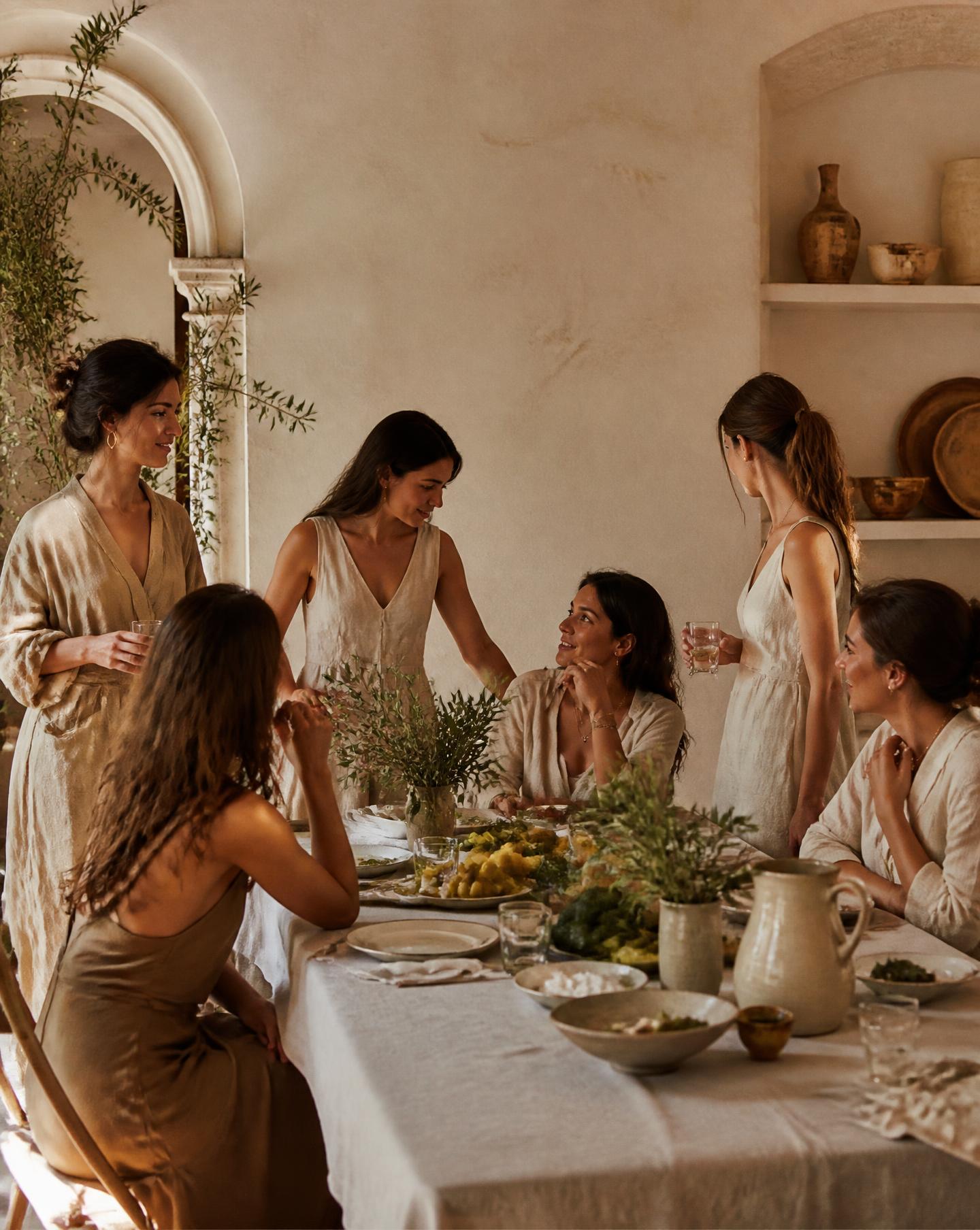Women gathered in linen in a sunlit Barcelona room during an Areté Society wellness experience